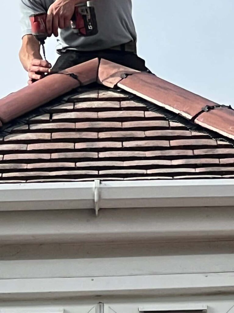 This is a photo of one of the operatives of Eastwood Roofing Repairs installing new ridge tiles