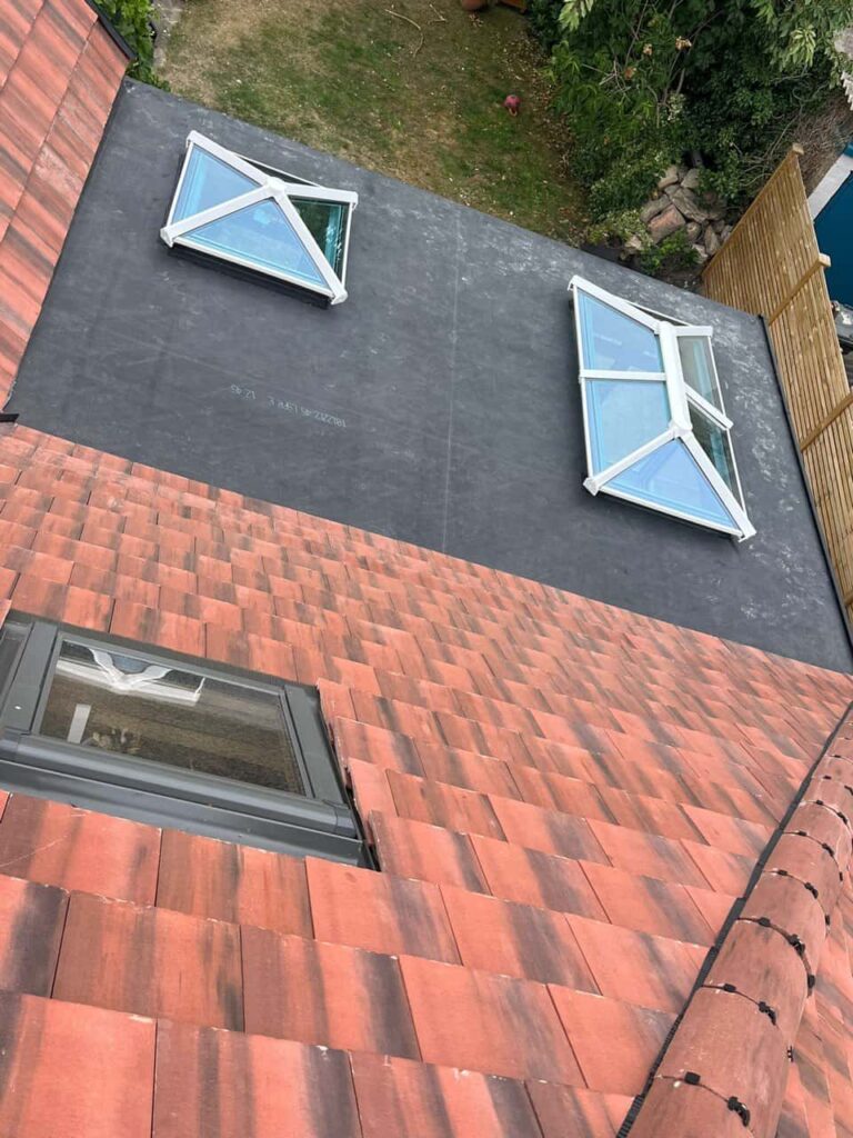 This is a photo taken from the roof ridge looking down a tiled pitched roof on to a flat roof. Works carried out by Eastwood Roofing Repairs