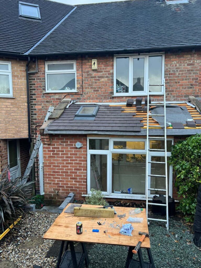 This is a photo of a roof extension that is having new roof tiles installed. This is a photo taken from the roof ridge looking down a tiled pitched roof on to a flat roof. Works carried out by Eastwood  Roofing Repairs